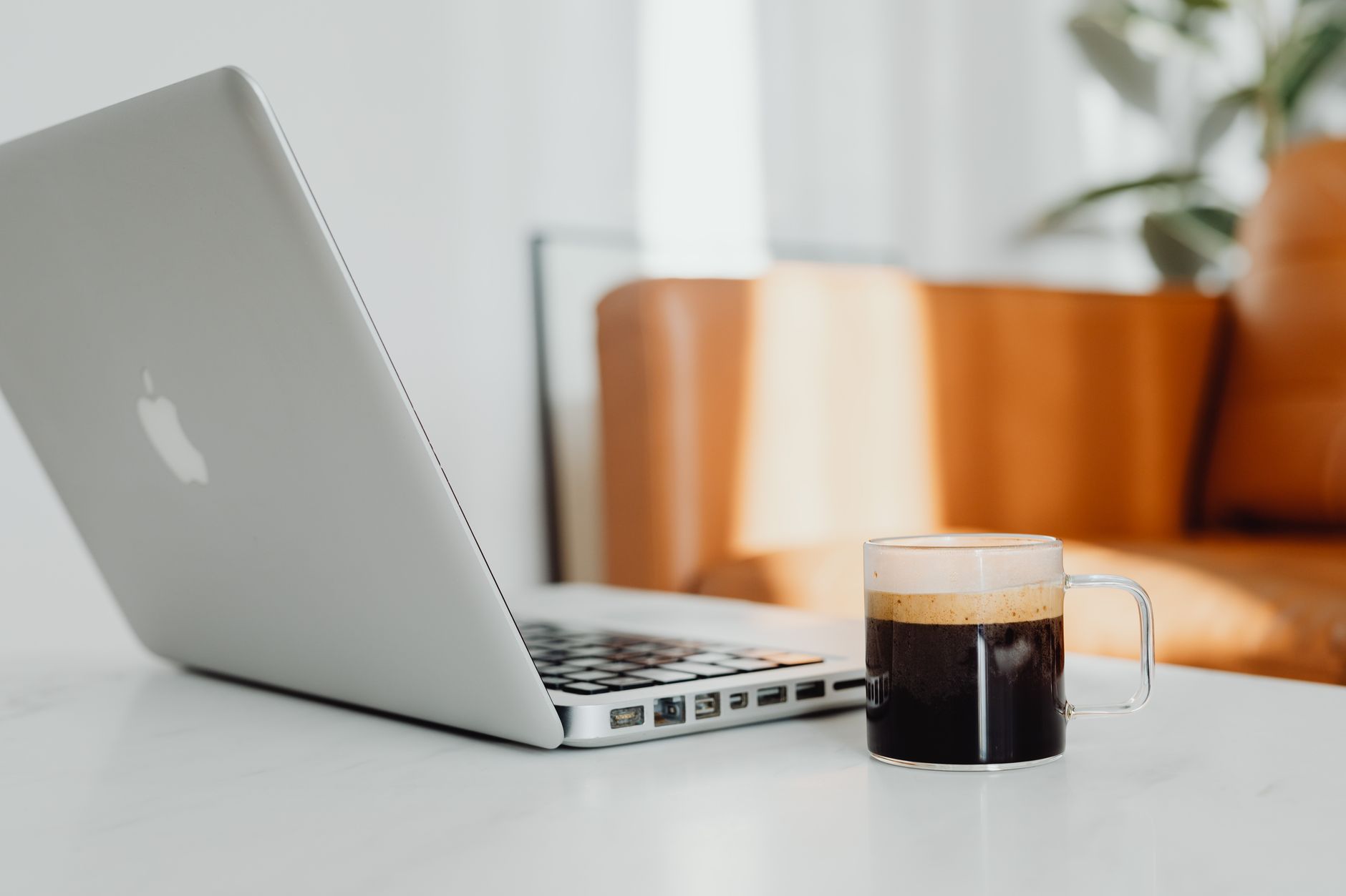 Un salon confortable avec un ordinateur portable et une tasse de café posés sur un bureau.